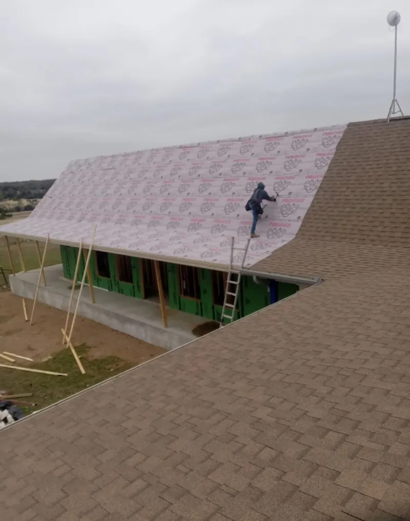 Worker preparing underlayment for a metal roof installation in Newnan